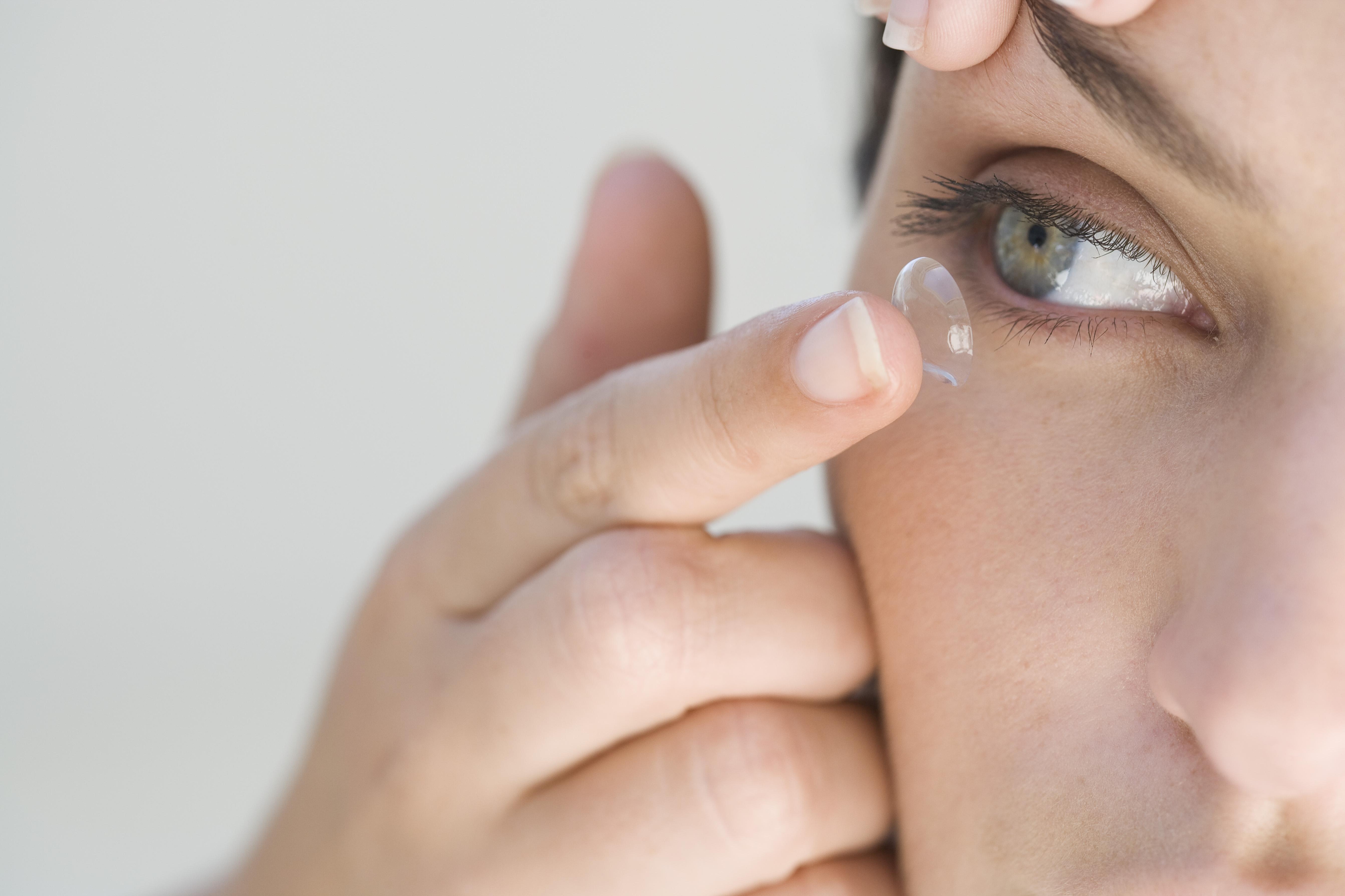 Woman inserting contact lens