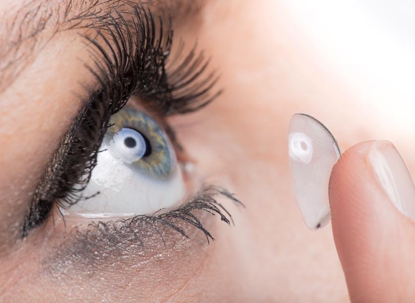 Young woman Inserting a contact lens, close-up