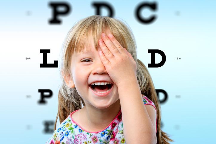Niña rubia tapándose un ojo