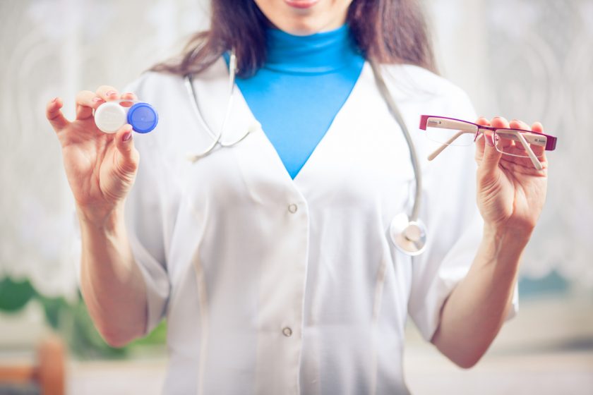 Enfermera sostiene unas gafas y un estuche para lentillas
