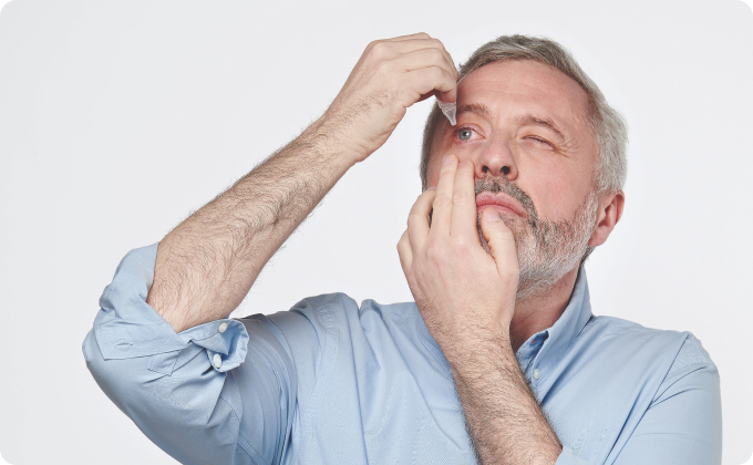 hombre maduro echándose gotas en un ojo
