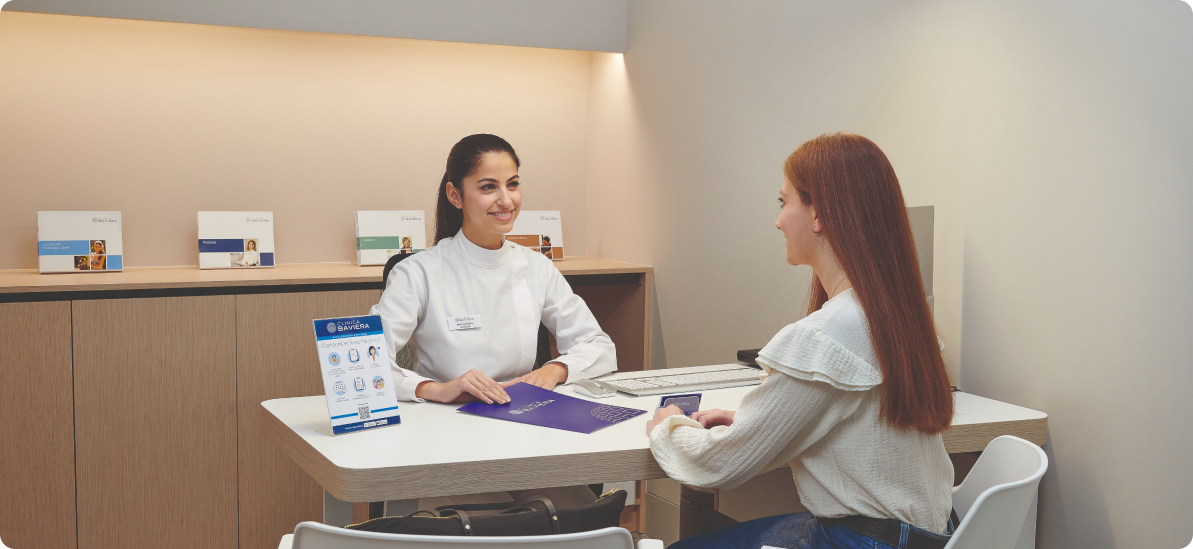 auxiliar de clínica atendiendo a una paciente joven pelirroja