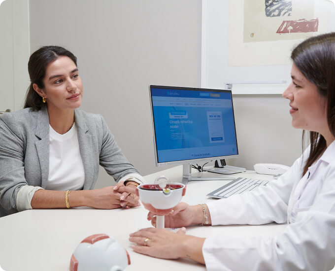 médico y paciente joven con jersey azul junto a un foróptero