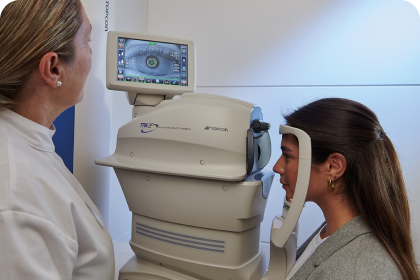 auxiliar y mujer joven con jersey gris durante una prueba oftalmológica