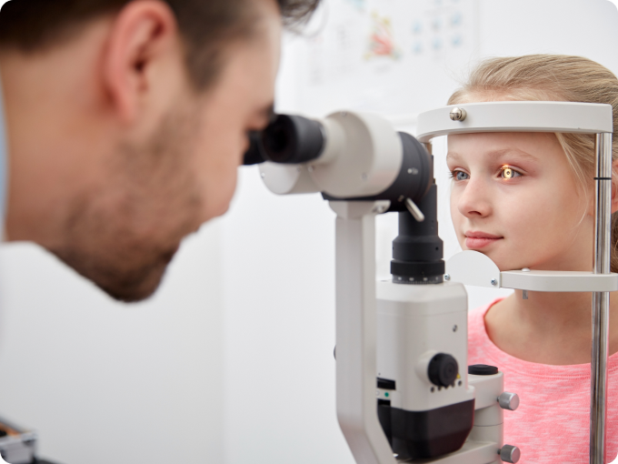 niña rubia con ojos verdes durante un examen con lámpara de hendidura