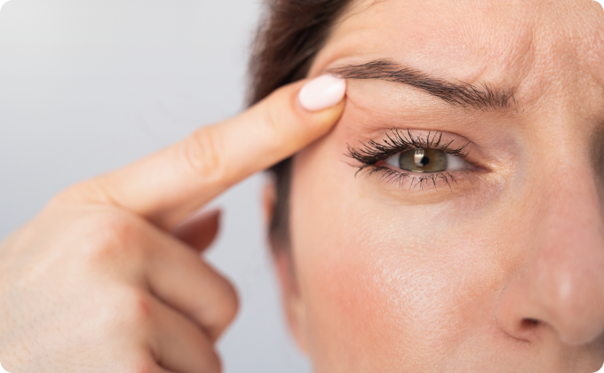 mujer mirándose un ojo y subiéndolo con un dedo