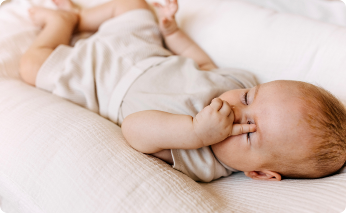 bebé durmiendo tocándose un ojo