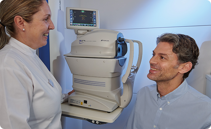 hombre maduro y axiliar de clínica durante una prueba oftalmológica