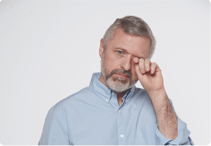 hombre de mediana edad frontándose el ojo