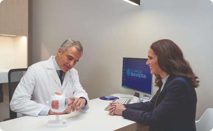 oftalmólogo explicándole las partes del ojo a mujer joven en consulta