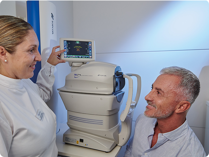 auxiliar y hombre maduro canoso durante una prueba oftalmológica