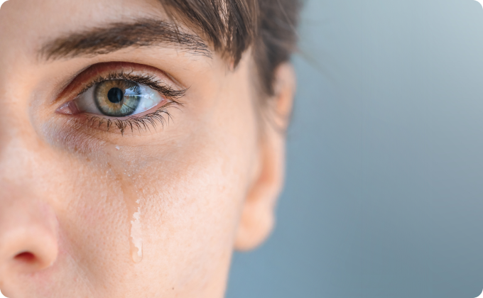 niña rubia sentada en mesa tapándose un ojo
