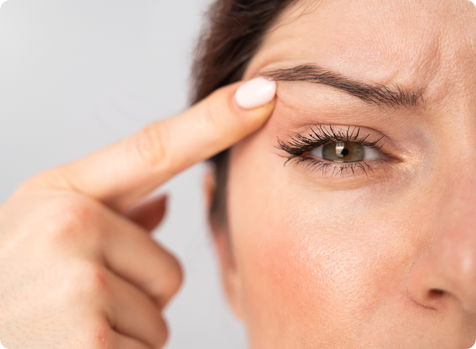 mujer mirándose un ojo y subiéndolo con un dedo