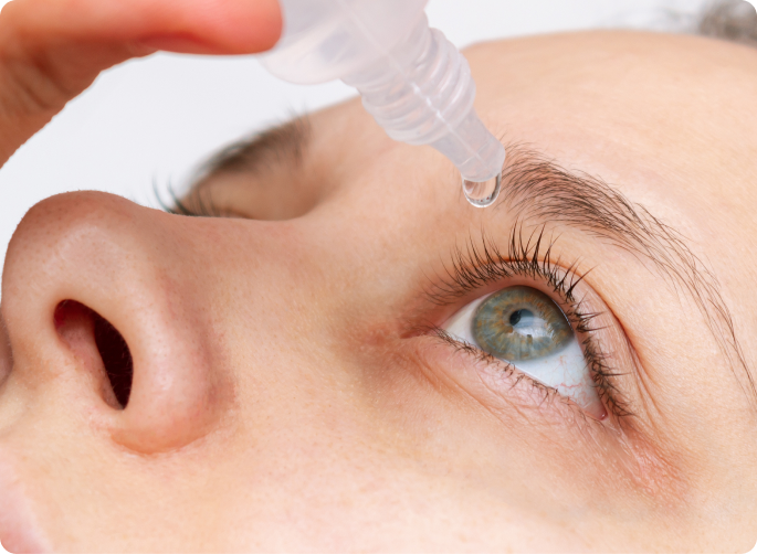 mujer joven instilándose gotas en el ojo