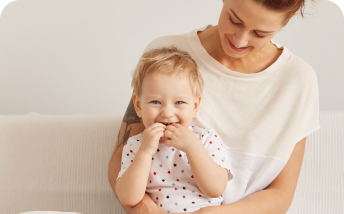 niño en el regazo de mujer tocándose la boca