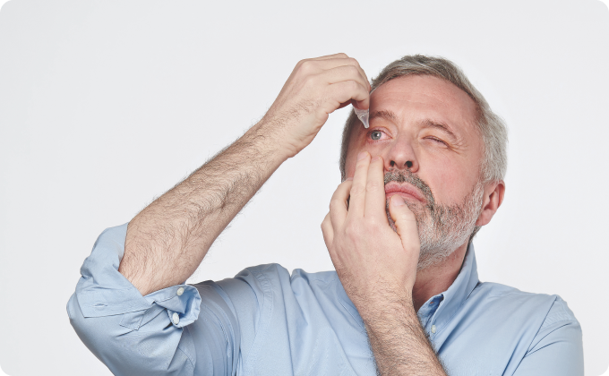 hombre maduro echándose gotas en el ojo