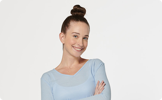 mujer joven con jersey gris y camiseta blanca mirando hacia arriba