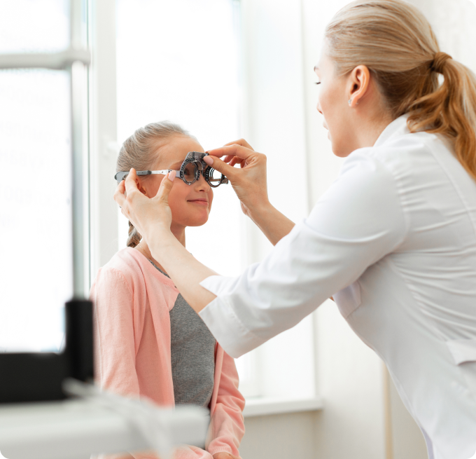 oftalmóloga y niña rubia con trenza durante una prueba oftalmológica