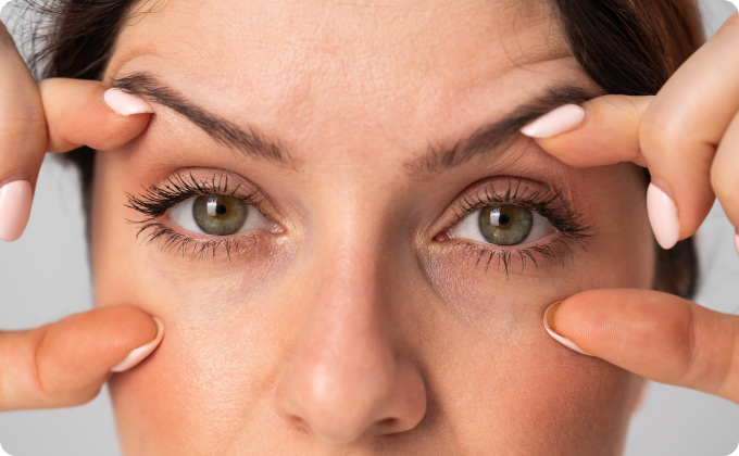 mujer abriéndose los ojos con los dedos