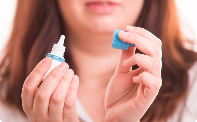 mujer mostrando cómo se abre un colirio