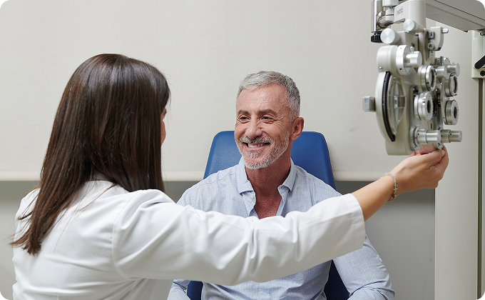 médico y hombre paciente maduro después de una prueba con foróptero