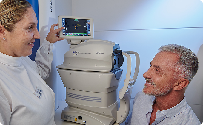 auxiliar y hombre maduro canoso durante una prueba oftalmológica