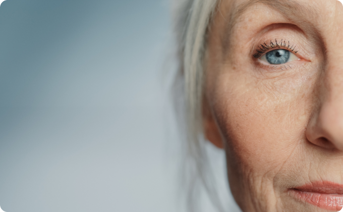 primer plano ojo azul de mujer canosa con el pelo recogido