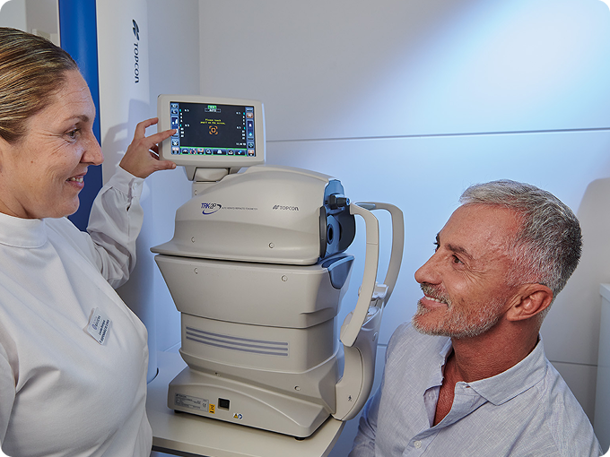 auxiliar y hombre maduro canoso durante una prueba oftalmológica