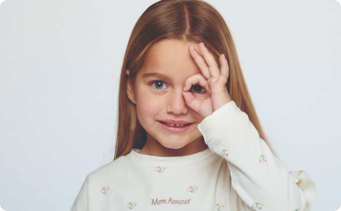 niña haciéndose un círculo sobre un ojo