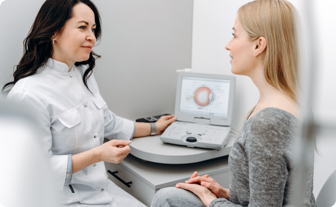 oftalmóloga mostrándole a una paciente rubia las partes del ojo