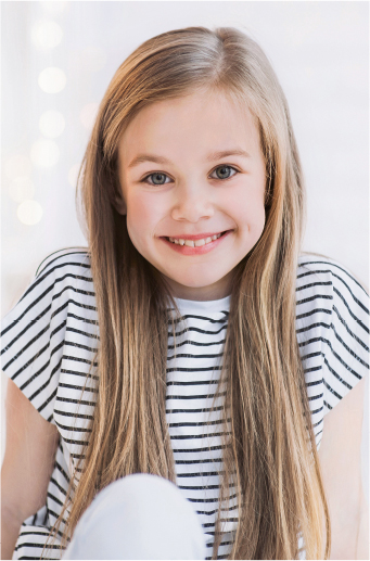 Nia rubia con camiseta a rayas sonre