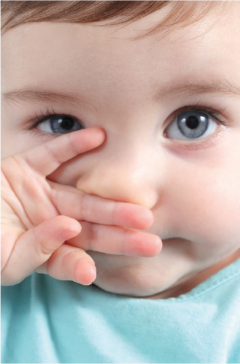 Beb pelirrojo con ojos azules se tapa la boca