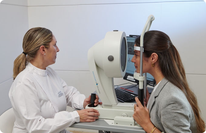 auxiliar y mujer joven durante una topografía corneal